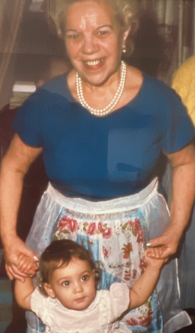 Two generations — a grandmother holding her grandchild's hands